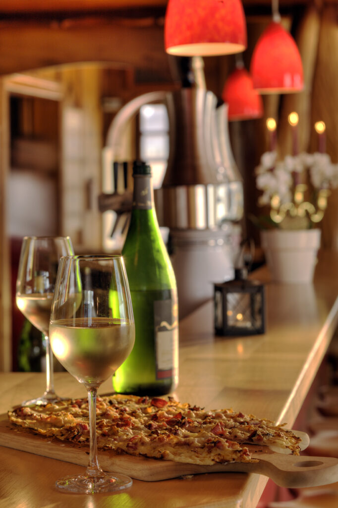 Flammkuchen mit zwei Gläsern Weißwein an der Theke im Wirtshaus Linnenkerl